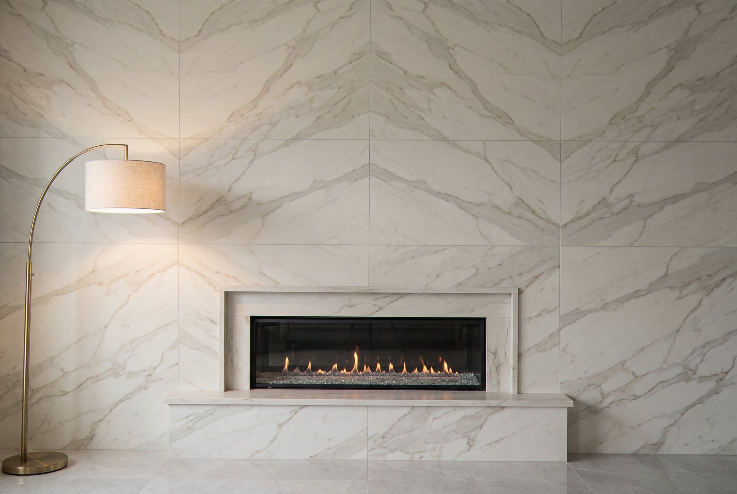 Floor to ceiling tile surround around a fireplace